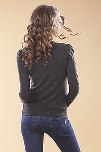 woman wearing black crew-neck long-sleeved top and blue jeans