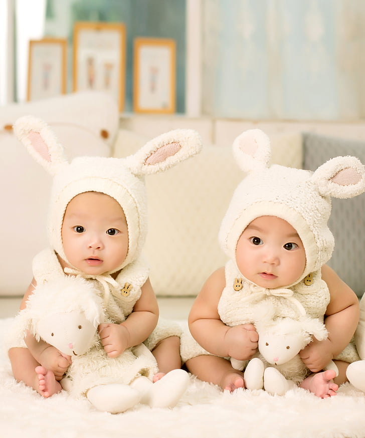 two babies in white rabbit costumes
