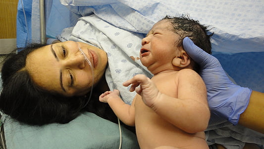 newborn baby shown to mother