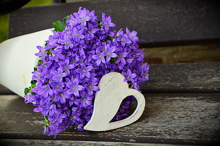 purple cluster flowers in white vase centerpiece closeup photo