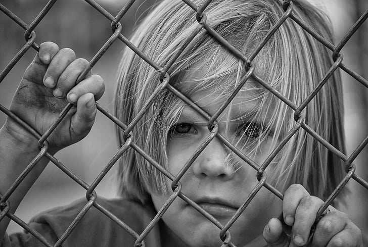 toddler in gray metal fence