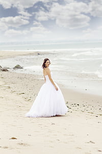 woman in white tube wedding dress standing on seashore on daytime