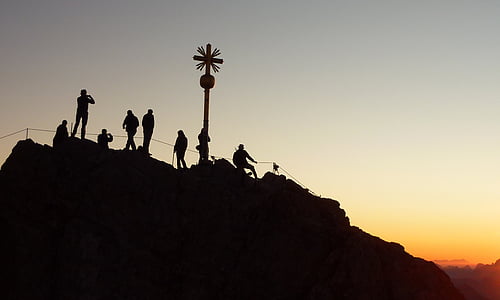 silhouette of group of people on hill during golden hour