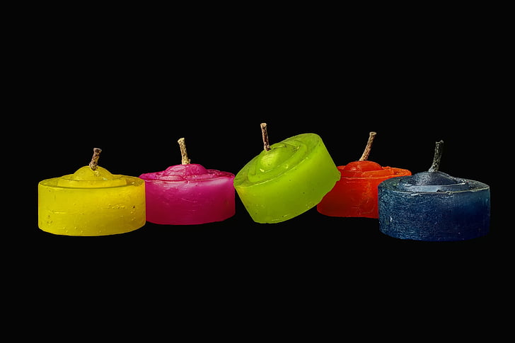 five assorted-color candles on black background