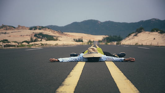 person lies on asphalt road