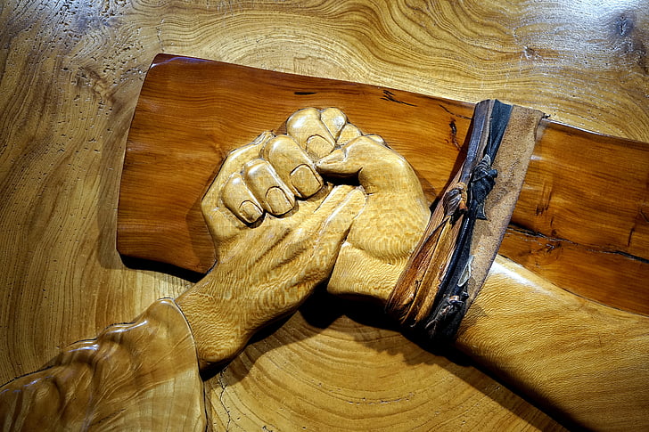 shallow photography of carved wood holding hands