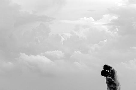 man carrying woman on clouds during daytime