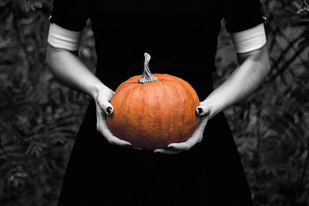 selective color photography of person holding pumpkin