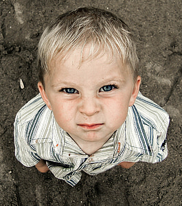 boy wearing plaid collared shirt staring above during daytime
