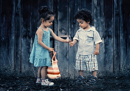 boy and girl holding flower photo