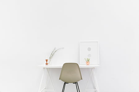gray armless chair and white wooden side table