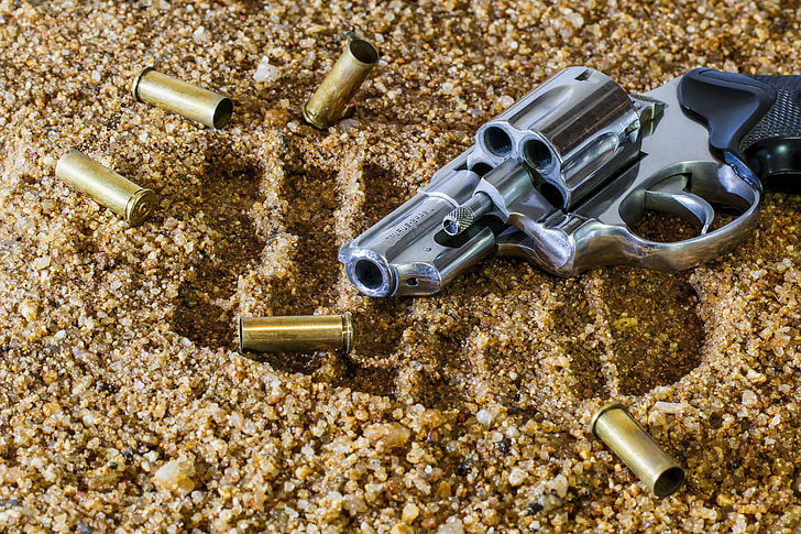 chrome revolver pistol on brown sands
