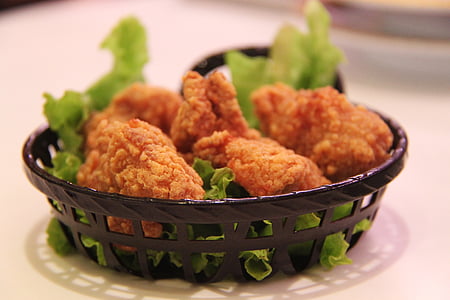 fried chicken with letus in round black mesh plate