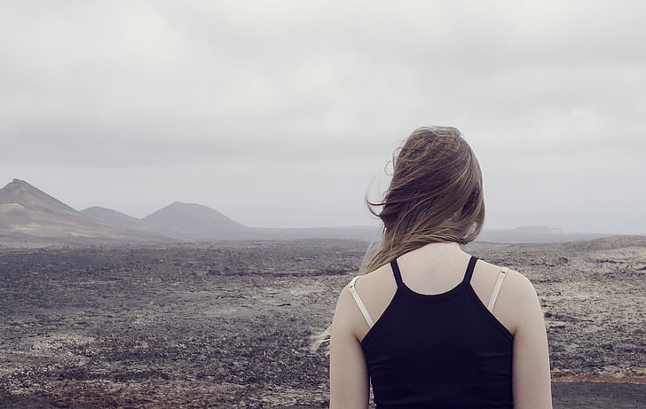 woman wearing black camisole top facing deserted land