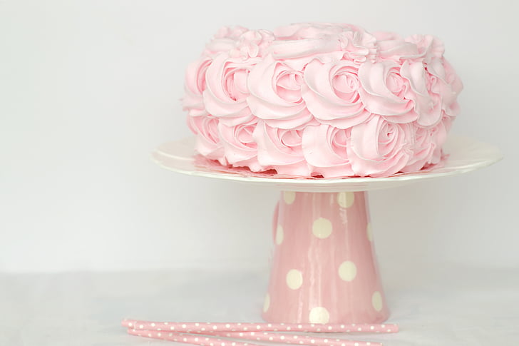 pink icing coated cake on white and pink cake stand