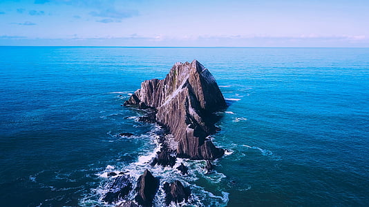 rock formation surrounded with body of water