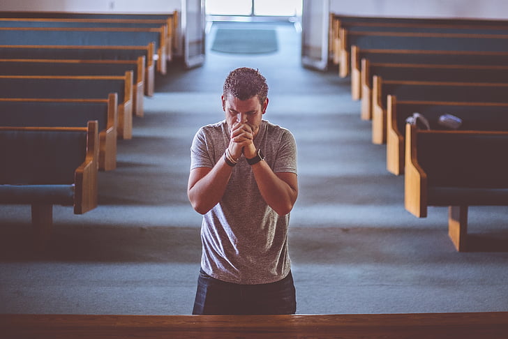man praying inside the church