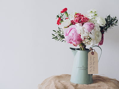 red, pink, and white peonies and carnations centerpiece in teal metal watering can