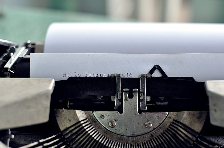 close-up photo of black typewriter with white paper