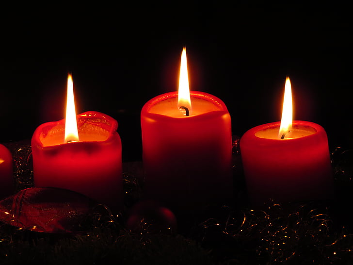 three red lighted votive candles