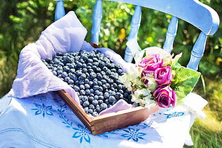 blueberries beside pink roses