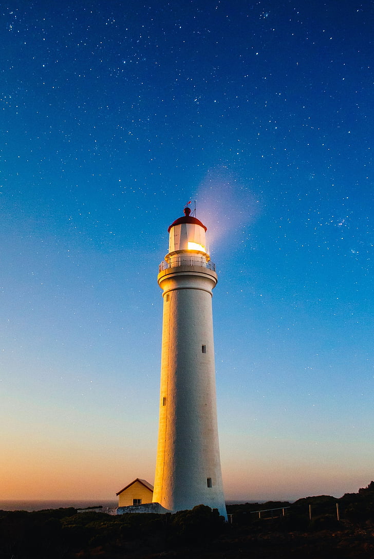 white lighthouse photography during night