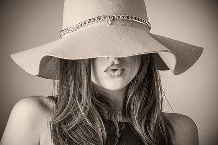 grayscale photo of woman wearing floppy hat and sleeveless shirt