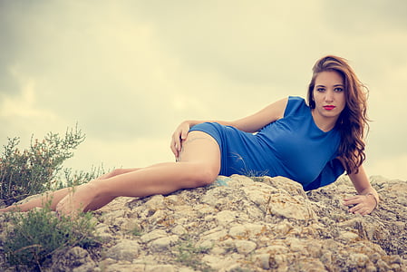 woman lying on rock wearing blue mini dress