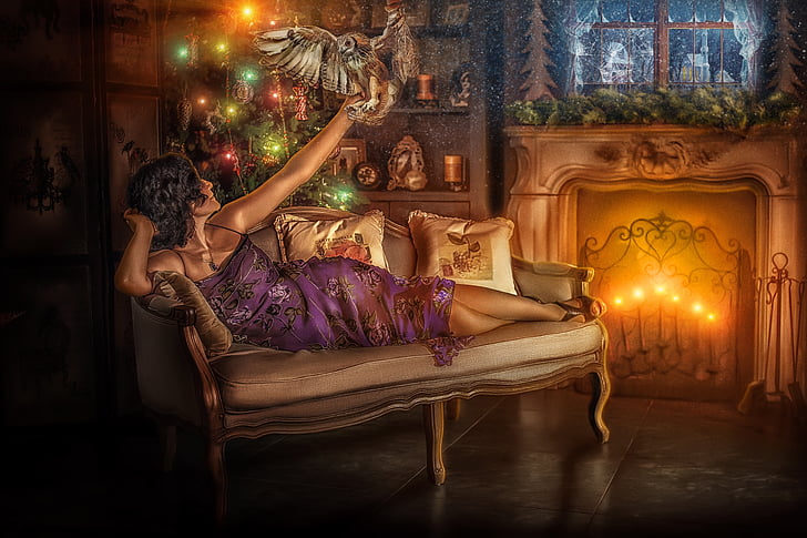 black hair woman in purple dress lying on sofa while holding bird during night time