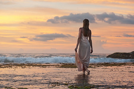 woman in white dress walking on body of water