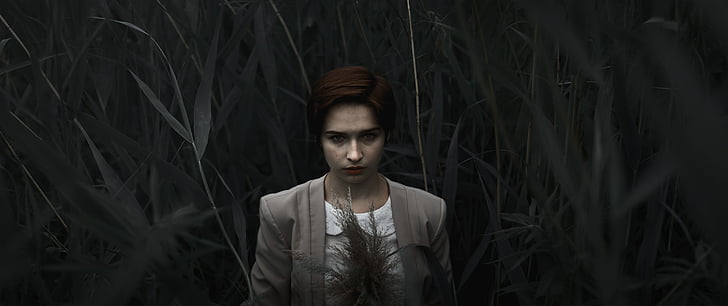 woman in gray blazer surrounded by grass