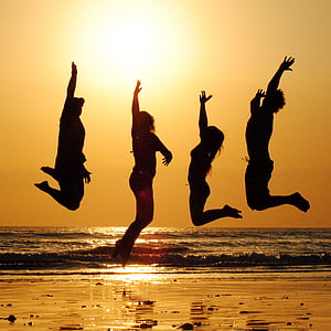 silhouette of four people jumping