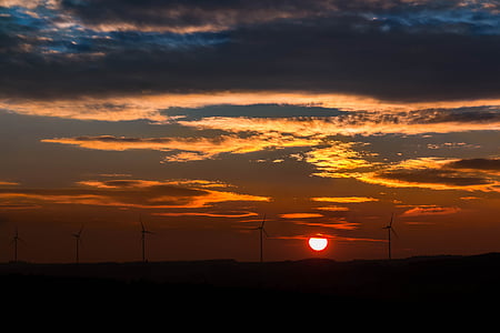 silhouette of windmills on sunset