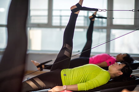 woman performing leg exercise inside gym