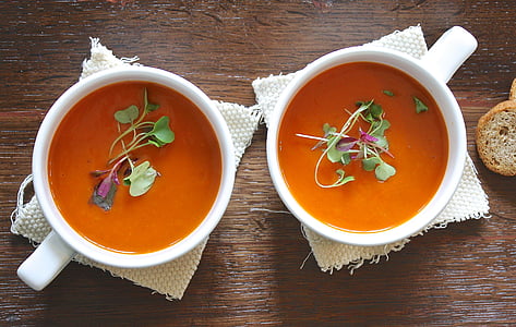 two white ceramic cup with soup and vegetable