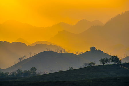 green coated hills during sunset