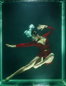 underwater photography of woman wearing red zip-up bodysuit