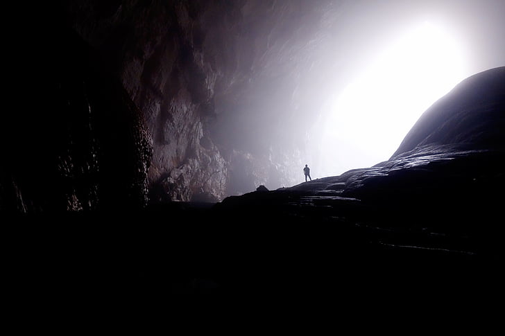 person standing on cave