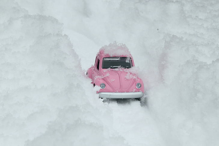 pink Volkswagen Beetle scale model on snow