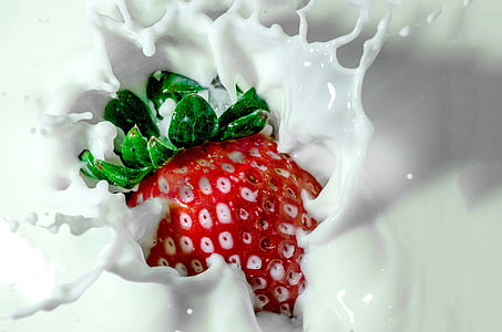timelapse photography of strawberry tossed into milk