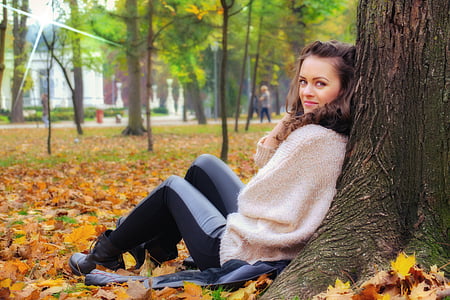 woman sitting on tree roots at daytime