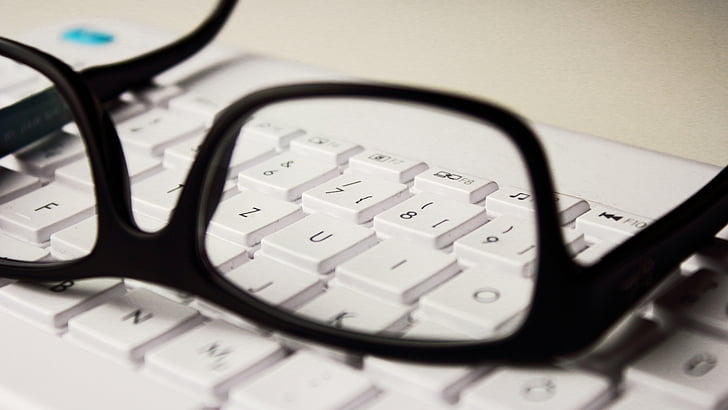 black framed eyeglasses and white comptuer keyboard