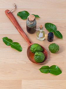 two green fruits on spoon near vials