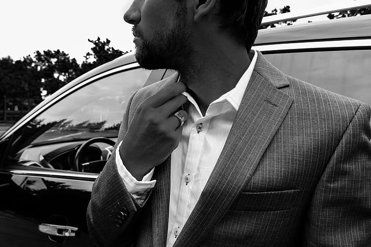 grayscale photography of man wearing formal suit