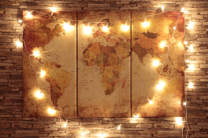 world man 3-panel decor with string lights mounted on brown bricked wall