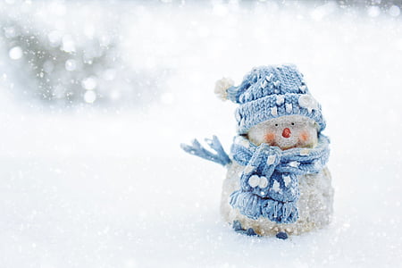 snowman wearing knit cap in snow