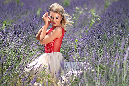 woman in red sleeveless top and white skirt sitting in lavender field