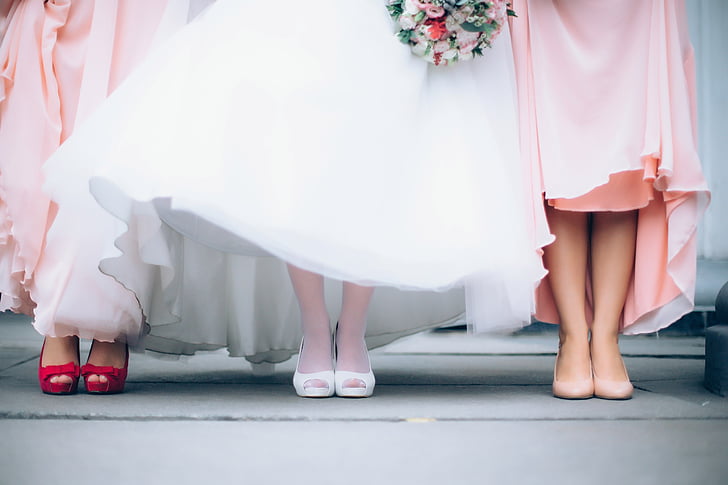 two woman wearing pink dress with woman wearing white dress