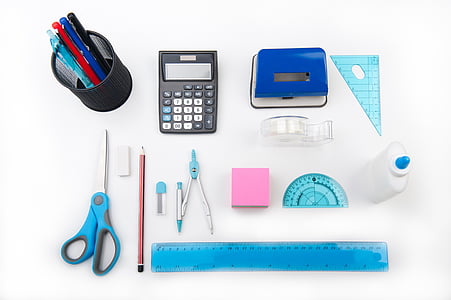 black desk calculator, blue scissor and glue bottle