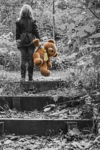 selective color photography of woman holding brown bear plush toy